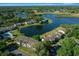 An aerial view highlights the community pool and nearby condos, boasting a picturesque lake and mature trees at 515 Midway Dr # A, Ocala, FL 34472