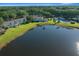 An aerial view of lakefront condos featuring well-maintained green spaces and a community pool under a clear blue sky at 515 Midway Dr # A, Ocala, FL 34472