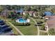 Overhead view showcasing community pool, mature palms and condo units near lake and golf course at 515 Midway Dr # A, Ocala, FL 34472