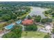 Aerial view showcases community amenities including a lake, pools, and tennis courts surrounded by trees at 515 Midway Dr # A, Ocala, FL 34472
