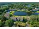 An aerial view shows the condo overlooking a lake with lush surroundings and easy access to a community pool at 515 Midway Dr # A, Ocala, FL 34472