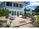 Serene backyard brick patio with lounge chair and outdoor dining set overlooking a tranquil lake at 515 Midway Dr # A, Ocala, FL 34472