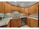 Kitchen with light granite counters, tile backsplash, stainless steel dishwasher, and light wood cabinets at 515 Midway Dr # A, Ocala, FL 34472