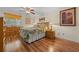 Inviting bedroom with wood floors, ceiling fan, and a floral-patterned bedspread at 515 Midway Dr # A, Ocala, FL 34472