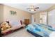 Cozy bedroom with neutral walls, ceiling fan, and a comfortable-looking bed with a colorful quilt at 8237 108Th Street Sw Rd, Ocala, FL 34481