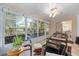Bright sunroom with large windows, wicker furniture, and a ceiling fan for comfortable relaxation at 8237 108Th Street Sw Rd, Ocala, FL 34481