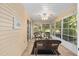 Enclosed sunroom filled with natural light, featuring wicker furniture and a ceiling fan at 8237 108Th Street Sw Rd, Ocala, FL 34481