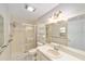 Well-lit bathroom featuring a shower with glass doors and a large mirror at 8831 Sw 94Th Ln # H, Ocala, FL 34481