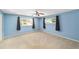 A light blue bedroom with two windows and a ceiling fan at 8831 Sw 94Th Ln # H, Ocala, FL 34481