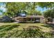 Backyard showcasing a covered lanai, lush landscaping, and a well-maintained lawn creating a tranquil outdoor space at 8831 Sw 94Th Ln # H, Ocala, FL 34481