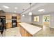 Eat-in kitchen with light wood cabinets, black appliances, and kitchen island, leads to living room at 8831 Sw 94Th Ln # H, Ocala, FL 34481