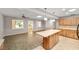 View from eat-in kitchen showing kitchen island, light countertops and light wood cabinetry, and adjacent living room at 8831 Sw 94Th Ln # H, Ocala, FL 34481