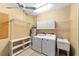 Functional laundry room equipped with washer, dryer, sink, storage cabinets, and shelving for added convenience at 8831 Sw 94Th Ln # H, Ocala, FL 34481
