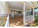 Inviting covered front porch with stone accents, white railings, and tile flooring at 8831 Sw 94Th Ln # H, Ocala, FL 34481