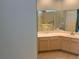 Bathroom with a walk-in tub and light-colored countertops with warm cabinets and flooring at 9288 Sw 93Rd Cir, Ocala, FL 34481