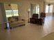 Cozy living room featuring tiled floors, comfortable seating, and screened sliding-glass doors at 9288 Sw 93Rd Cir, Ocala, FL 34481