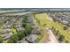 Overhead view of homes bordering a golf course featuring mature trees, sand traps, and a walking path at 9591 Sw 70Th Loop, Ocala, FL 34481