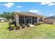 Well-maintained backyard with a screened in lanai, lawn, and landscaped shrubs enhancing privacy at 9591 Sw 70Th Loop, Ocala, FL 34481