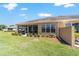 A home's backyard featuring a screened in patio and a well manicured lawn at 9591 Sw 70Th Loop, Ocala, FL 34481