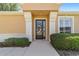 Front door with decorative glass, framed by lush landscaping and columns at 9591 Sw 70Th Loop, Ocala, FL 34481