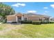 Traditional home with manicured lawn, mature landscaping and modern front door at 9591 Sw 70Th Loop, Ocala, FL 34481