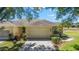 Attached two-car garage and mature landscaping with view of the golf course at 9591 Sw 70Th Loop, Ocala, FL 34481