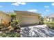 Attached two-car garage with lovely landscaping, and concrete driveway at 9591 Sw 70Th Loop, Ocala, FL 34481