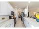 Modern kitchen with white cabinetry, stainless steel appliances, and sleek countertops, seamlessly connecting living spaces at 9591 Sw 70Th Loop, Ocala, FL 34481
