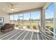 Relaxing screened-in lanai with cozy seating, ceiling fan, and views of the green landscape outside the screen windows at 9591 Sw 70Th Loop, Ocala, FL 34481