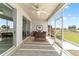 Inviting screened lanai featuring cozy seating, ceiling fan, and picturesque views of the lush backyard at 9591 Sw 70Th Loop, Ocala, FL 34481