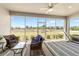 Relaxing screened-in lanai boasts comfortable seating, ceiling fan, and scenic views of the surrounding landscape at 9591 Sw 70Th Loop, Ocala, FL 34481