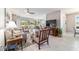 Open-plan living room with a ceiling fan, tile flooring, and access to the outdoor screened patio at 9591 Sw 70Th Loop, Ocala, FL 34481