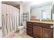 Neutral bathroom with vanity, framed mirror, shower and pink accents at 9721 Sw 53Rd Ct, Ocala, FL 34476