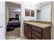 Bathroom featuring granite countertop, dark wood cabinets, and view of bedroom at 9721 Sw 53Rd Ct, Ocala, FL 34476