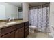 Bathroom featuring granite countertop, dark wood cabinets, toilet, and shower at 9721 Sw 53Rd Ct, Ocala, FL 34476