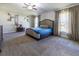 A spacious main bedroom with carpet, ceiling fan, neutral walls, and two large windows at 9721 Sw 53Rd Ct, Ocala, FL 34476