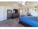A spacious main bedroom with carpet, ceiling fan, neutral walls, and two large windows at 9721 Sw 53Rd Ct, Ocala, FL 34476