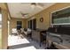 A covered patio includes ceiling fans, a grill, and cozy furniture at 9721 Sw 53Rd Ct, Ocala, FL 34476