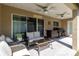 Covered outdoor patio with cushioned seating, ceiling fans, and grill at 9721 Sw 53Rd Ct, Ocala, FL 34476