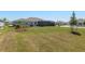 A wide view of the backyard featuring a screened-in patio, lawn, and landscaping at 9764 Sw 81St Ln, Ocala, FL 34481