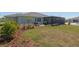 A wide view of the backyard featuring a screened-in patio, lawn, and landscaping at 9764 Sw 81St Ln, Ocala, FL 34481