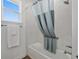 Bright bathroom featuring a tub with tile surround and a grey and white shower curtain at 9764 Sw 81St Ln, Ocala, FL 34481