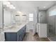 Well-lit bathroom featuring a double vanity, modern fixtures, and a glass-enclosed shower at 9764 Sw 81St Ln, Ocala, FL 34481