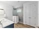 Modern bathroom features double doors, wood-style floors, a vanity with stone countertops, and a tiled walk-in shower at 9764 Sw 81St Ln, Ocala, FL 34481