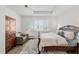 Relaxing bedroom featuring a decorative rug, a carved bed frame, plantation shutters, and a cozy seating area at 9764 Sw 81St Ln, Ocala, FL 34481