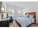 Comfortable bedroom with a wood bed frame, and a blue accent chair near the window at 9764 Sw 81St Ln, Ocala, FL 34481