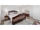 Inviting bedroom boasts wood-style floors, a decorative rug, a carved bed frame, and plantation shutters at 9764 Sw 81St Ln, Ocala, FL 34481