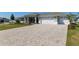 Paver driveway leads to a charming home with a two-car garage, and a beautifully landscaped lawn at 9764 Sw 81St Ln, Ocala, FL 34481