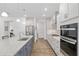 This gorgeous kitchen features an eat-in island, modern appliances, and white cabinets at 9764 Sw 81St Ln, Ocala, FL 34481