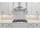 Modern kitchen features white cabinetry, stone countertops, subway tile backsplash, and stainless steel range hood at 9764 Sw 81St Ln, Ocala, FL 34481